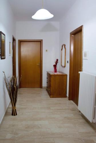 a hallway with a door and a vase on the floor at La Collina dei Ciliegi in Sarule
