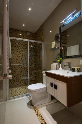 a bathroom with a toilet and a shower and a sink at Hotel Orion Tbilisi in Tbilisi City
