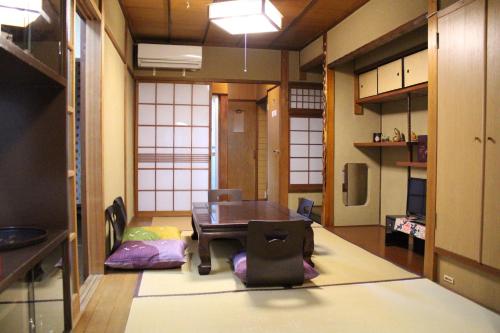 a room with a table and chairs in it at Guesthouse Higashiyama Jao in Kyoto