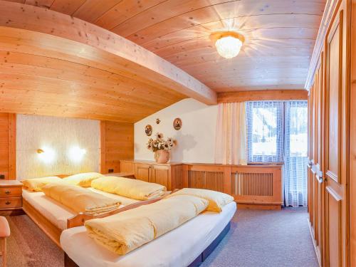 レンゲンフェルトにあるFerienhaus mit Kaminofen und Skiraum - A 152.006の木造の部屋にベッド3台が備わるベッドルーム1室