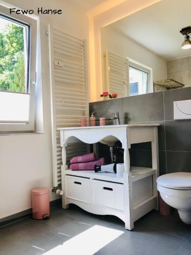 a bathroom with a white sink and a toilet at Ferienhaus - Am Kütertor - alle Apartments mit Terrasse oder Balkon - in top Lage in Stralsund