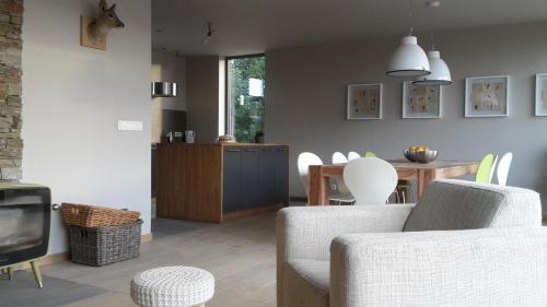 uma sala de estar com duas cadeiras e uma televisão e uma mesa em Ardennature vakantiehuizen met privé-sauna em La-Roche-en-Ardenne