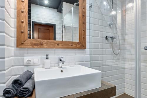 een badkamer met een witte wastafel en een spiegel bij STUDIO Apartment CENTER OLIMPIYSKA- 54 Velyka Vasylkivska Street in Kiev