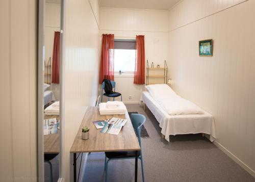 um quarto de hospital com uma cama e uma mesa em Sognhostel em Sørbø