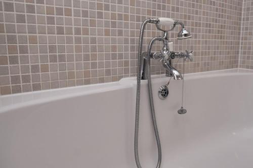 eine Dusche im Bad mit einer weißen Badewanne in der Unterkunft Old Bakers Cottage ground floor apartment centrally located in Grasmere with patio area in Grasmere