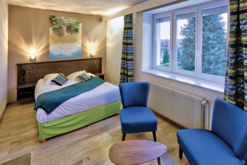 a hotel room with a bed and a chair and window at Logis Hotel Restaurant Spa Beau Site in Luxeuil-les-Bains