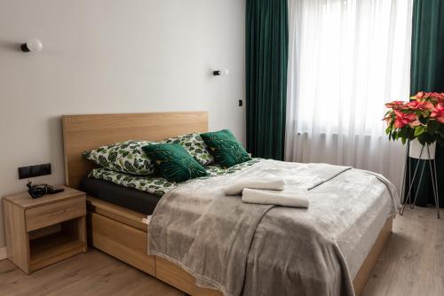 1 dormitorio con 1 cama con almohadas verdes en Apartament w centrum, en Gdynia