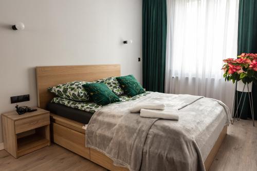 a bedroom with a bed with green pillows at Apartament w centrum in Gdynia