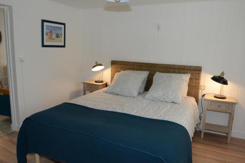 - une chambre avec un lit doté d'une couverture bleue et d'oreillers dans l'établissement Touline, à Saint-Malo