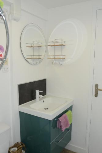 une salle de bain avec un lavabo et deux miroirs dans l'établissement Touline, à Saint-Malo