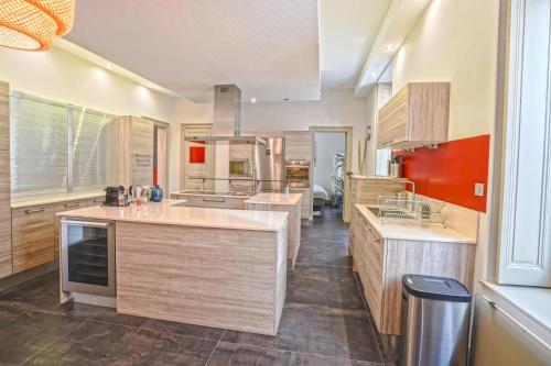 - une cuisine avec des placards en bois et un mur rouge dans l'établissement NOCNOC - Le Terracotta, à Montpellier