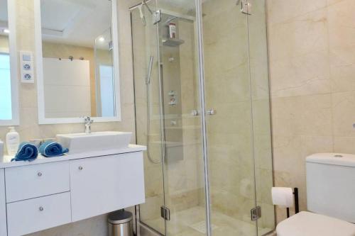 een badkamer met een douche, een wastafel en een toilet bij B3 Casares del Mar in Casares