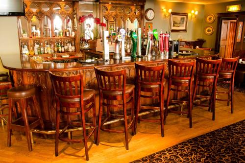 a bar with a bunch of wooden stools at Newbury Hotel in Mullingar