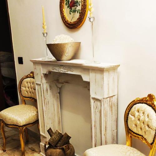 a white fireplace with two chairs and a bowl on top at B&B Palazzo Armini in Rogliano