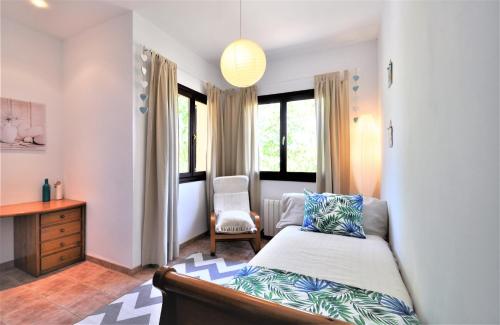 a bedroom with a bed and a chair and windows at C277 Son Rubi by Mallorca Villa Selection in Selva
