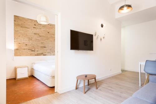 ロスピタレート・デ・リョブレガートにあるDesign Apartments by Olala Homesのベッドルーム1室(ベッド1台、壁にテレビ付)