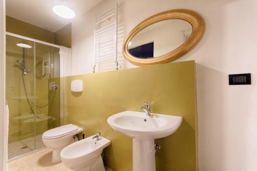 a bathroom with a sink and a toilet and a mirror at Le petit coeur de la ville in Turin