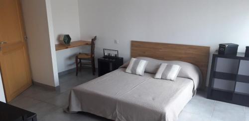 une chambre avec un lit avec deux oreillers dessus dans l'établissement Studio Indépendant avec parking fermé et sécurisé, à Lédenon
