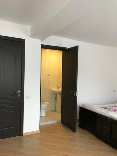 sypialnia z łóżkiem oraz łazienka z toaletą w obiekcie Zviad Guest House w Bordżomi