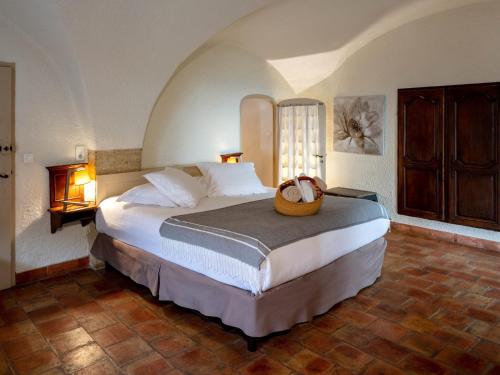 a bedroom with a bed with a basket on it at Garrigae Abbaye de Sainte Croix in Salon-de-Provence