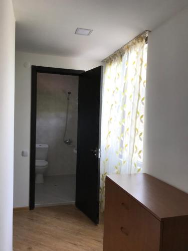 łazienka z toaletą i drzwiami do prysznica w obiekcie Zviad Guest House w Bordżomi