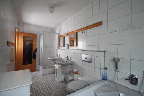 een badkamer met een toilet, een wastafel en een bad bij B&B am See Köln - Privatzimmer in Keulen