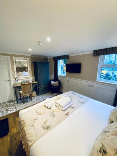 a bedroom with a large bed and a desk at The Inn At Grasmere in Grasmere
