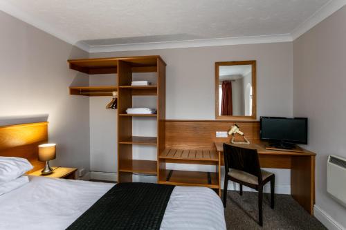 a hotel room with a bed and a desk with a computer at Roydon Marina Village Hotel in Roydon