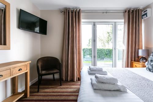 a hotel room with a bed and a window at Roydon Marina Village Hotel in Roydon