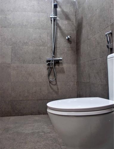 a bathroom with a toilet and a shower at OwinHill Cottage in Ella