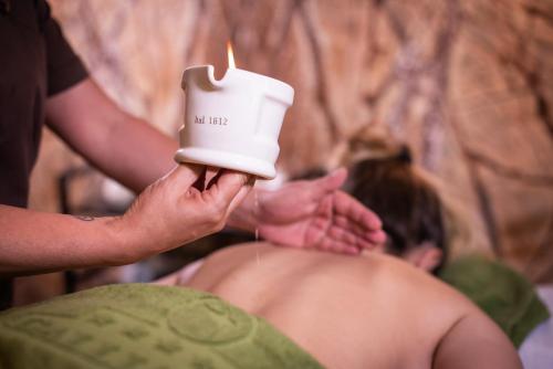 a man getting a bath with a candle at Gallia Palace Hotel - Relais & Châteaux in Punta Ala