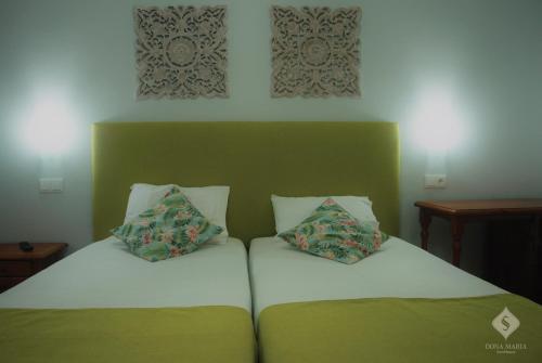 a bed with two pillows on top of it at Dona Maria in Portalegre