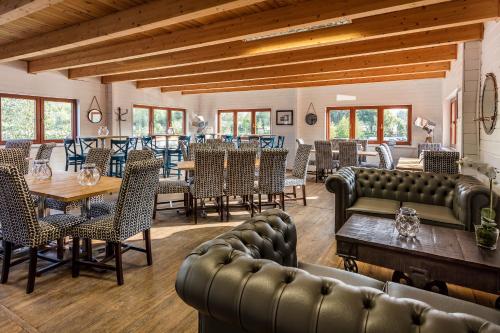 a dining room with leather chairs and tables and tablesktop at Roydon Marina Village Hotel in Roydon