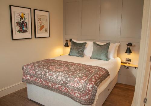 a bedroom with a large bed with two pillows at The Kings Arms Hotel in Malmesbury