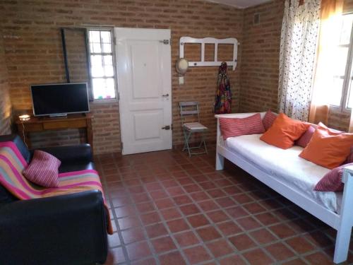 a living room with a couch and a tv at Casa Dos, casita de campo in Alta Gracia