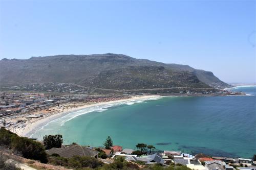 a view of a beach with houses and a mountain at South Peninsula Beach Apartment in Cape Town
