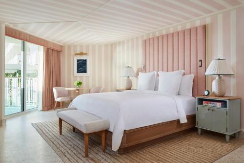 a hotel room with a bed and a desk at Four Seasons Resort Palm Beach in Palm Beach