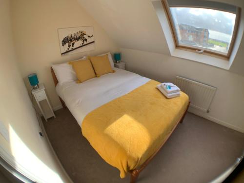 a small bedroom with a large bed with a window at Harpers brook house, Netflix TVs and fast WIFI in Corby