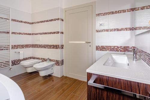 La salle de bains blanche est pourvue de toilettes et d'un lavabo. dans l'établissement Trento View, à Trente