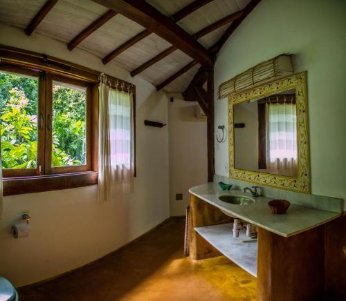 a bathroom with a sink and a mirror at Espaço Pégasus in Trancoso