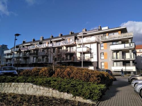 un edificio con coches estacionados en un estacionamiento en Art Apartment, en Giżycko