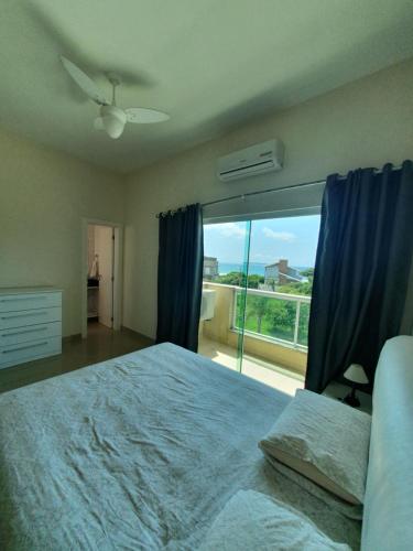 a bedroom with a large bed and a large window at Cobertura Jacuzzi Vista Mar in Bombinhas