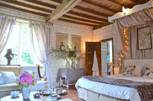 1 dormitorio con 1 cama y 1 mesa con flores en Manoir Francis en Marles-sur-Canche