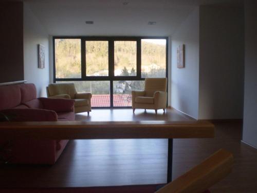 a living room with chairs and a large window at Hotel Amenal in Amenal