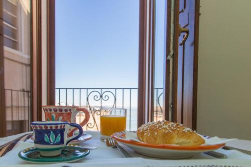 a table with a plate of bread and a glass of orange juice at Residenza Sveva in Termoli