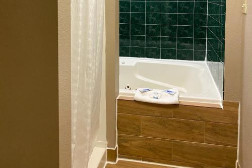 y baño con bañera y toalla. en Americas Best Value Inn New Boston, en New Boston