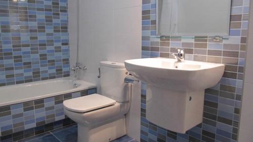a bathroom with a white toilet and a sink at Hotel Amenal in Amenal