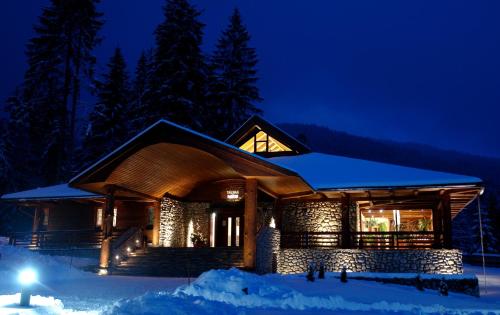 a log home in the snow at night at Hotel Partizán in Tale