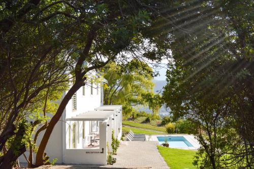 
a white house with a tree in front of it at Maison Montagne in Franschhoek
