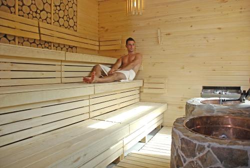 a man is sitting in a sauna at Hotel Partizán in Tale